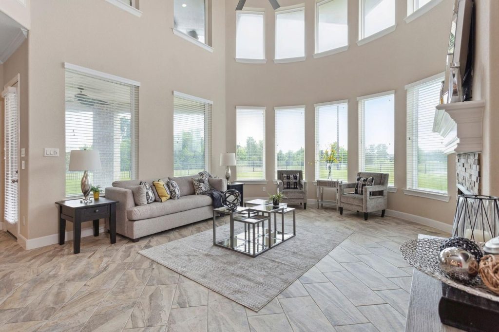 Cozy living room with modern sectional sofa, large windows, and fireplace, showcased by Licensed Real Estate Agent Sugar Land.