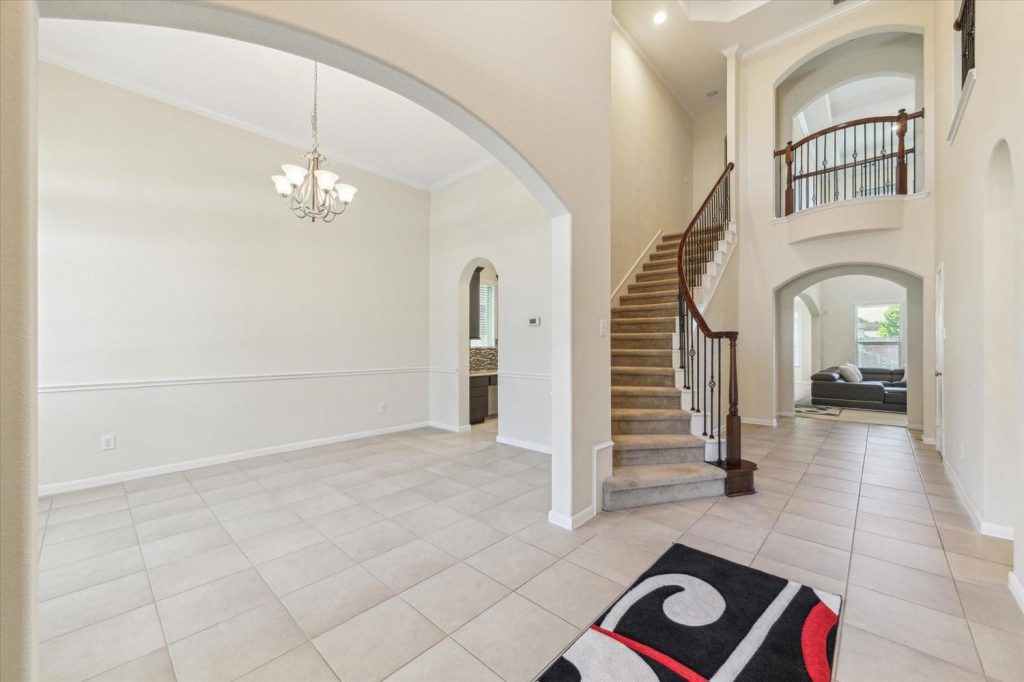 Spacious interior with grand staircase, perfect for a Licensed Real Estate Agent Sugar Land to highlight luxury homes.