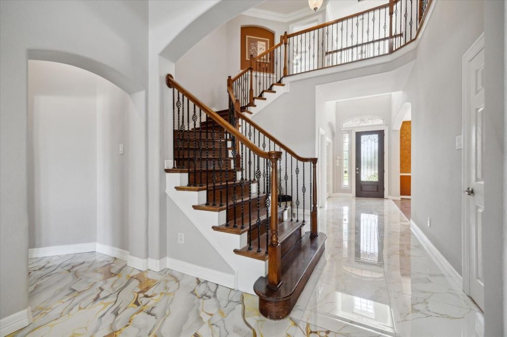 Elegant Sugar Land home foyer with curved staircase, ideal for listings by top home selling agents in Sugar Land.