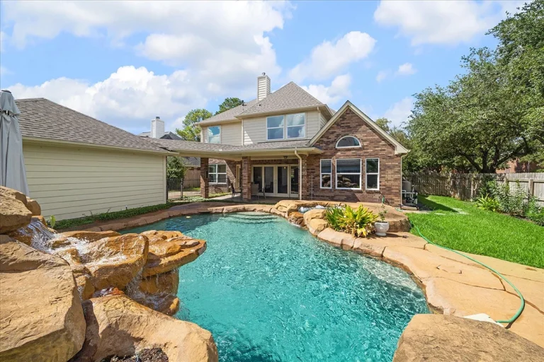 Spacious home with a stunning pool and waterfall in Sugar Land, listed by a licensed real estate agent.