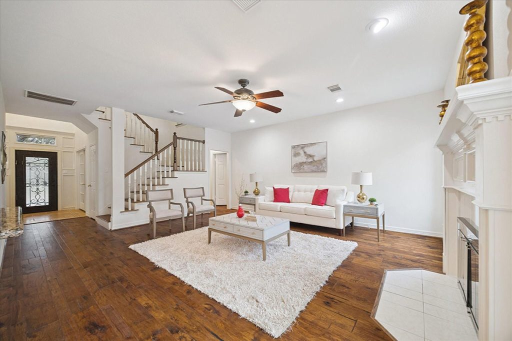 Elegant Sugar Land living room with fireplace and staircase, beautifully listed by licensed real estate agent sugar land