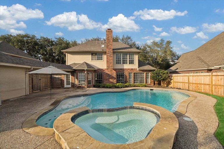 Sugar Land backyard with pool and hot tub at a two-story home, presented by licensed real estate agent sugar land