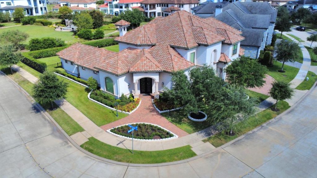 Upscale Sugar Land neighborhood with Mediterranean homes, park fountain, manicured streets—licensed real estate agent sugar land