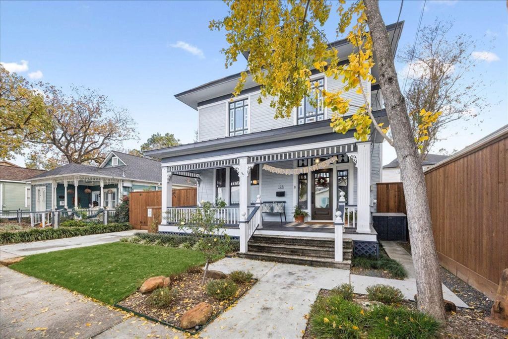 Charming Victorian-style two-story home with inviting front porch and manicured lawn, expertly marketed by Home Selling Agents Sugar Land.