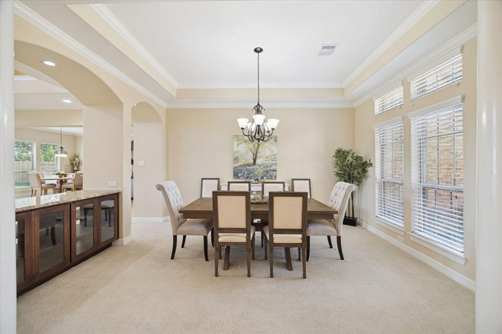 Spacious dining room with chandelier, upholstered chairs, and natural light—perfect for asking about entertaining space and interior upgrades.