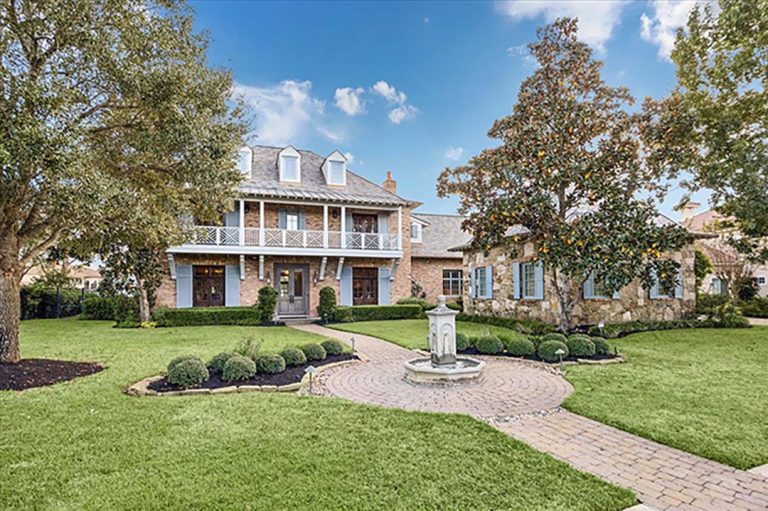 Grand Sugar Land brick estate with blue shutters, balcony, fountain, and guest wing, listed by real estate agent broker sugar land