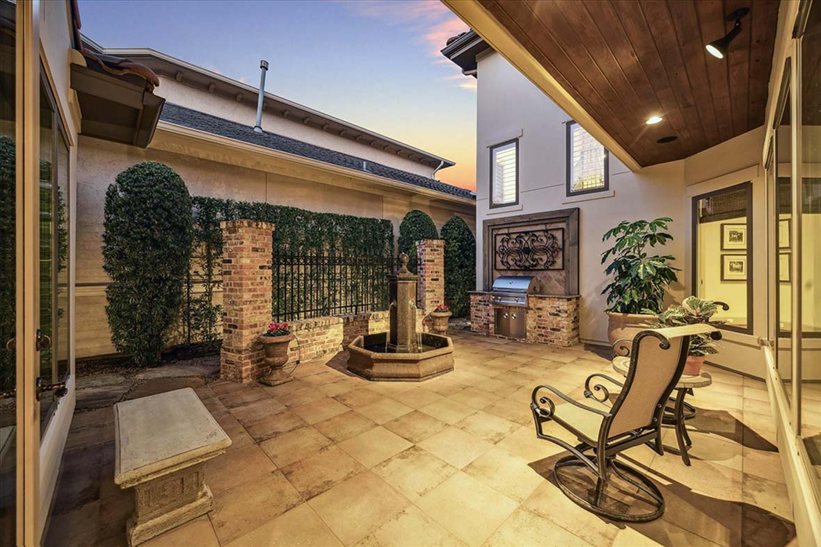 Outdoor patio with fountain, grill, and seating area—highlighting lifestyle features to ask about during early realtor consultations.