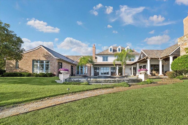 Luxury Sugar Land home with brick siding, columns, dormers, landscaped yard, palm trees, by house realtor sugar land