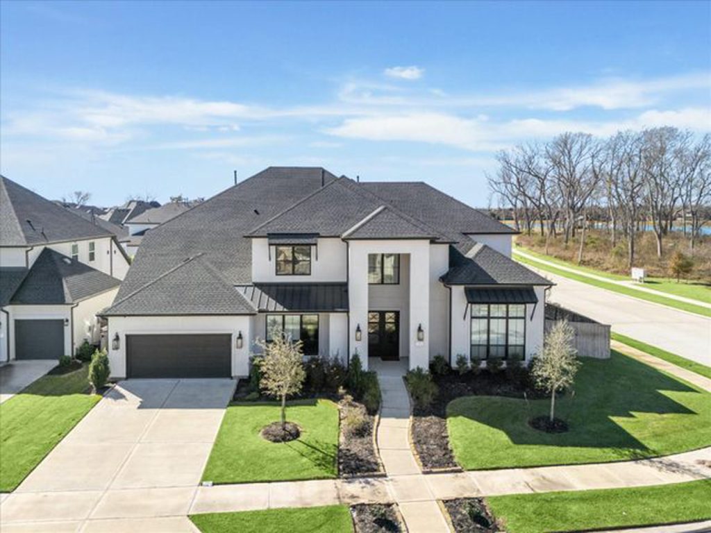 Aerial view of a beautiful white Sugar Land house with black trim and landscaping, showcasing a property from a local realtor.
