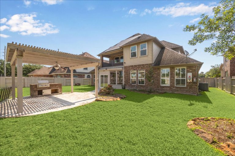 Licensed Real Estate Broker Sugar Land highlights backyard with pergola, built-in grill, and landscaped garden