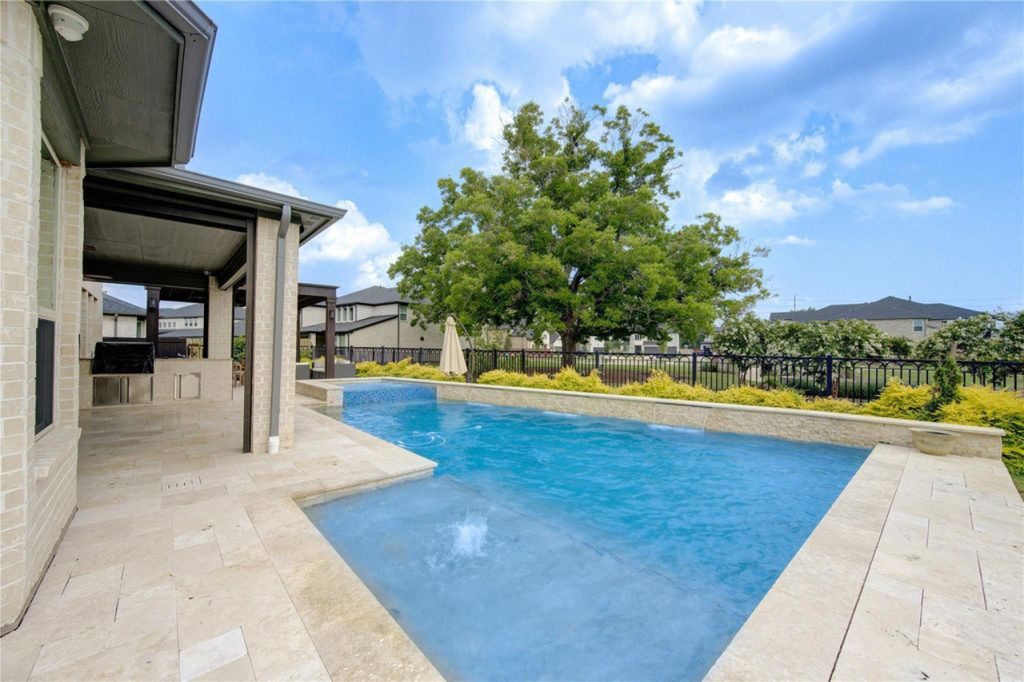 Realtor Broker Sugar Land presents backyard with swimming pool, covered patio, and built-in outdoor kitchen