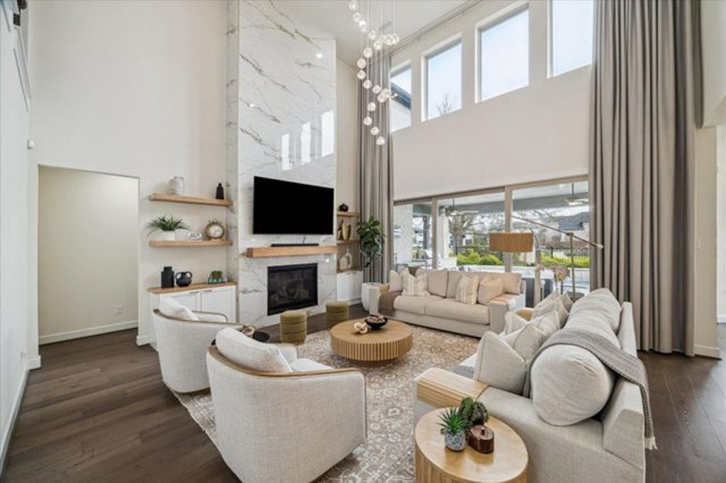 Realtor Broker Sugar Land showcases luxury living room with marble fireplace, tall windows, and modern furnishings