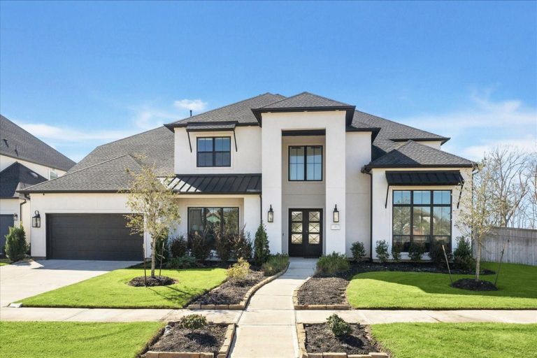 Front exterior of a modern Sugar Land house with large windows, garage, and pathway, presented by an experienced realtor.