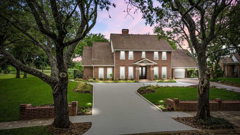 Licensed Real Estate Broker Sugar Land showcases luxury brick home with manicured lawn and sunset curb appeal.
