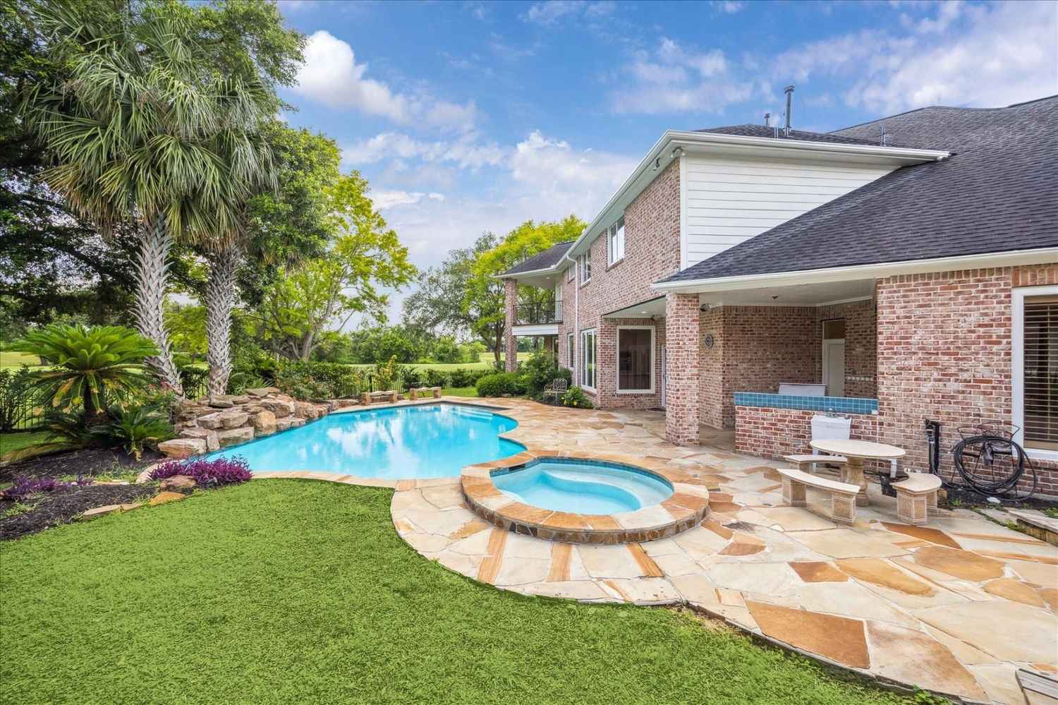 Stunning backyard oasis with resort-style pool and covered patio at this luxury home – Licensed Real Estate Agent Sugar Land