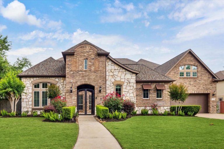 A grand stone and brick residence with curb appeal, a top listing from a premier licensed real estate broker Sugar Land.
