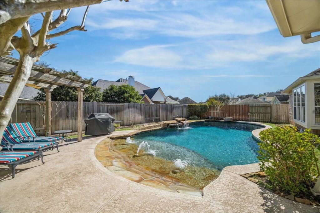 Backyard with pool and pergola, showcased by a real estate agent broker Sugar Land.