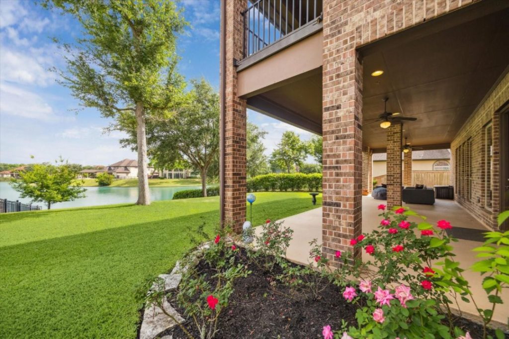 Beautiful lakeside patio with a rose garden, the perfect outdoor space sold by a licensed real estate broker Sugar Land.