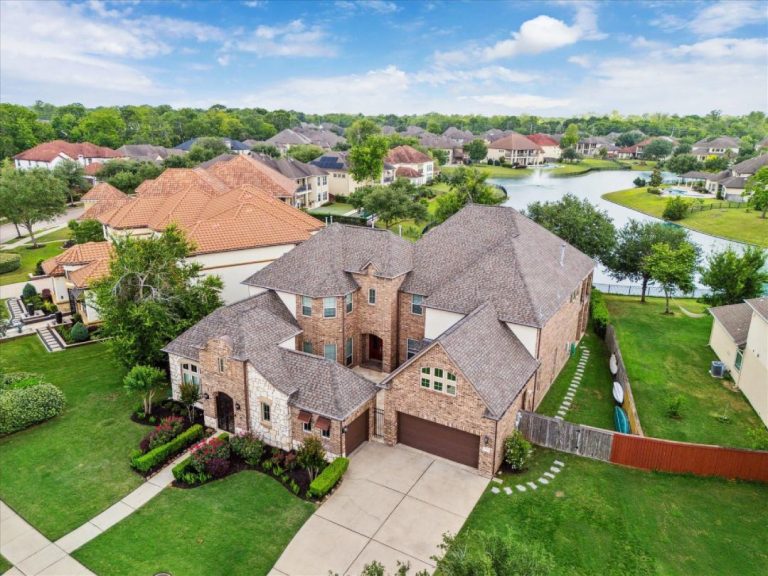 High-angle view of a stunning waterfront home, proudly represented by a local licensed real estate broker Sugar Land.