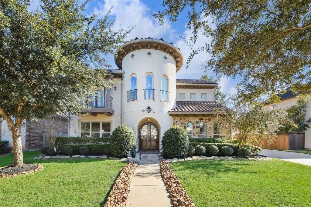Striking Mediterranean home featuring a stucco turret and stone accents, listed by a top real estate agent broker Sugar Land.