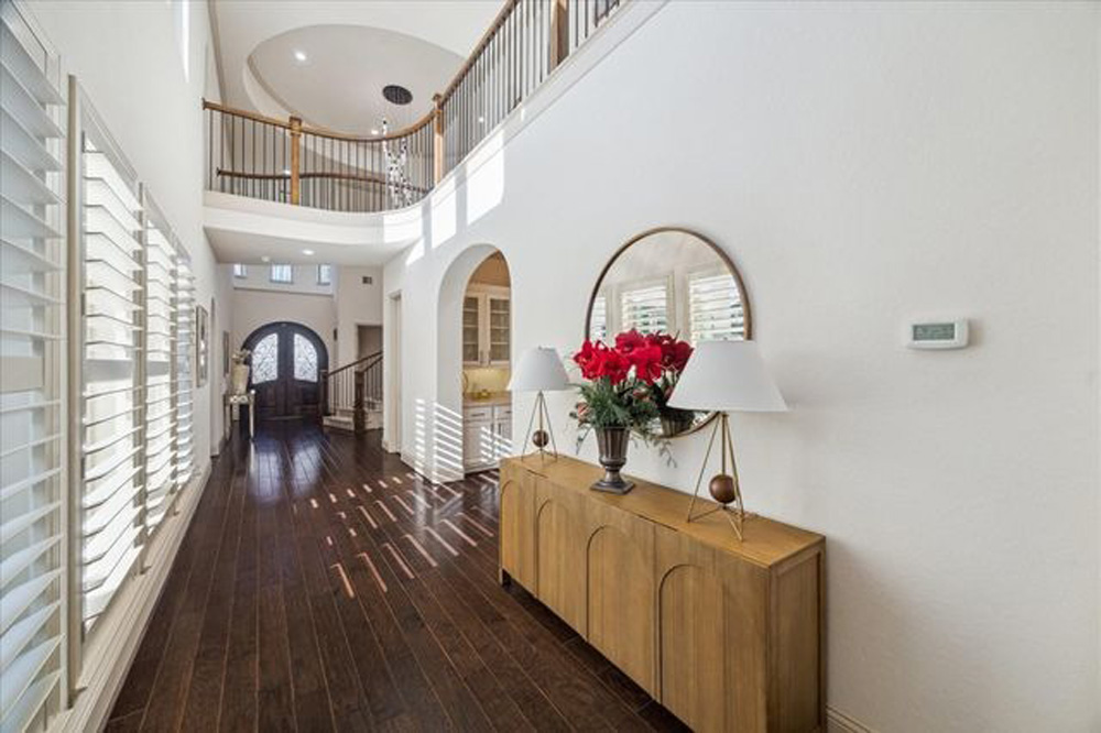 Elegant home foyer with dark hardwood floors and natural light, ready to help sell my home Sugar Land TX fast.
