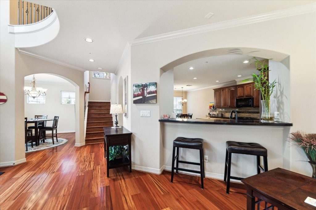 Open-concept modern Sugar Land home interior with hardwood floors and a kitchen pass-through.