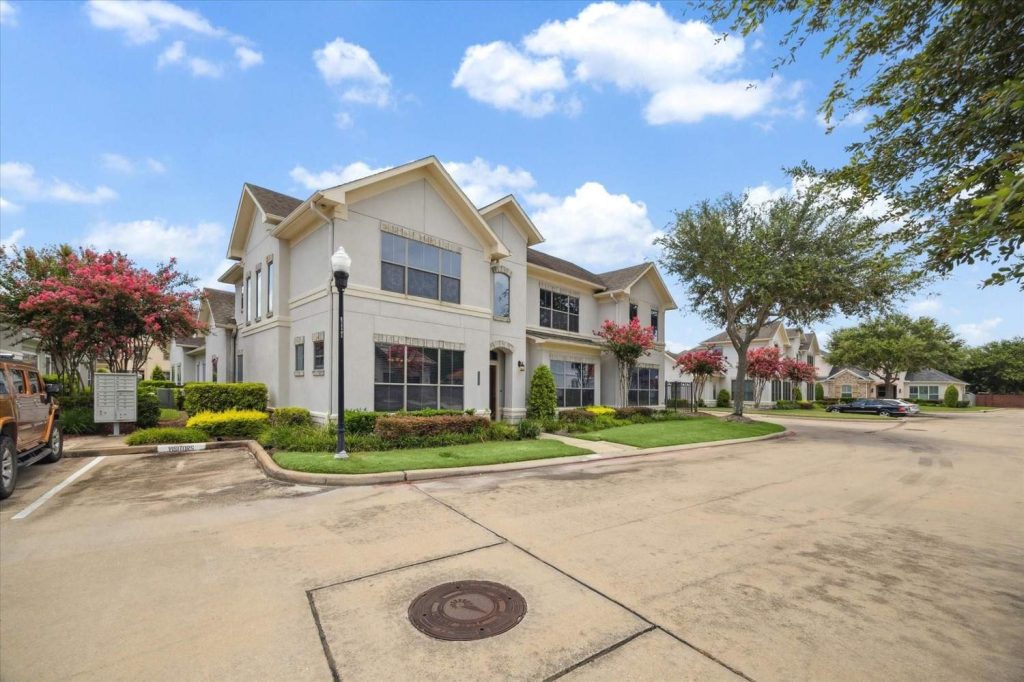 Modern multi-story Sugar Land townhomes with garages and neat landscaping.