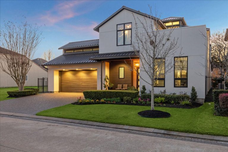 A sleek modern luxury home with architectural lighting at sunset, listed by a premier Sugar Land luxury real estate agent.