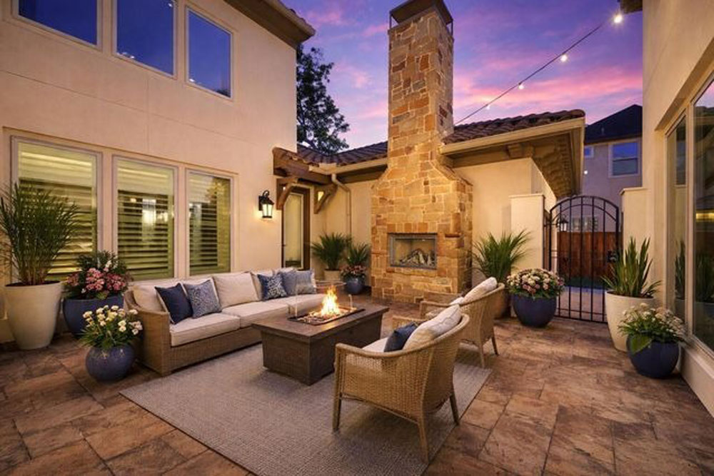 Stunning outdoor patio with stone fireplace and fire pit, a feature used to sell my home Sugar Land TX for top dollar.