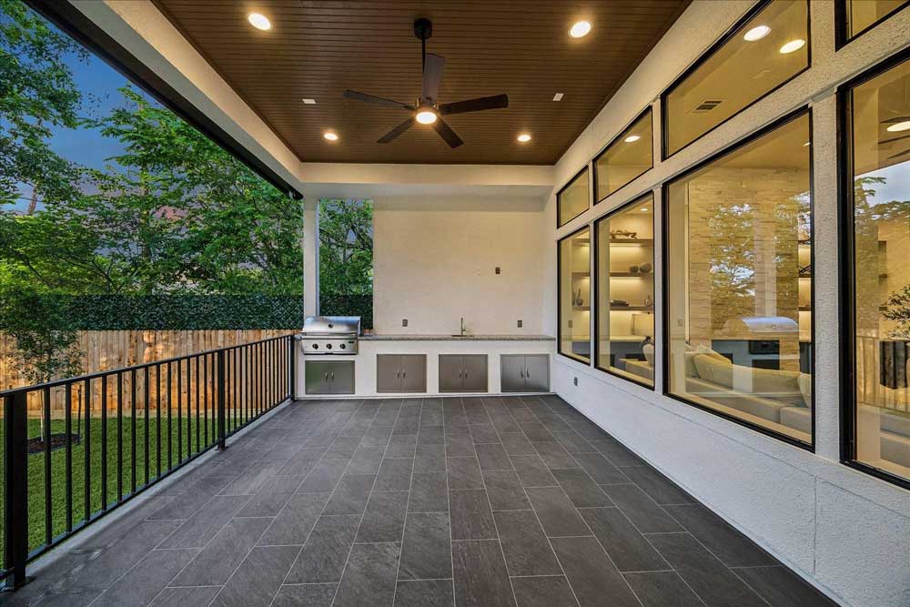 Luxury covered outdoor patio with built-in kitchen, a feature highlighted by expert home selling agents sugar land for a quick home sale.