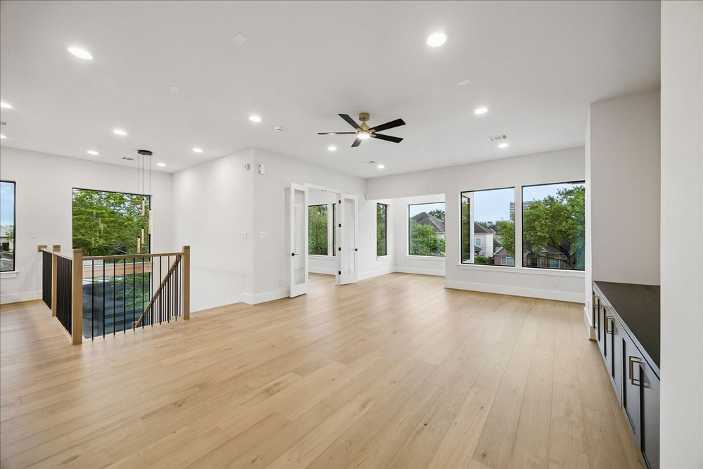 Spacious modern open home interior with light wood floors, listed by top home selling agents sugar land for a quick and profitable sale.