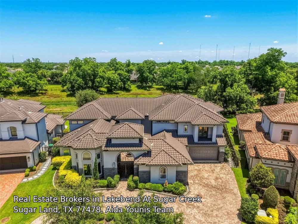 Aerial view of a luxury home represented by real estate brokers Sugar Land, featuring a brown tile roof and lawns.