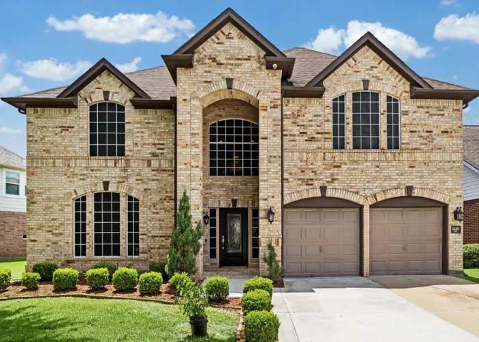 Stately brick two-story home exterior with two-car garage at 1226 Oxford Mills Lane, Sugar Land, TX 77479.