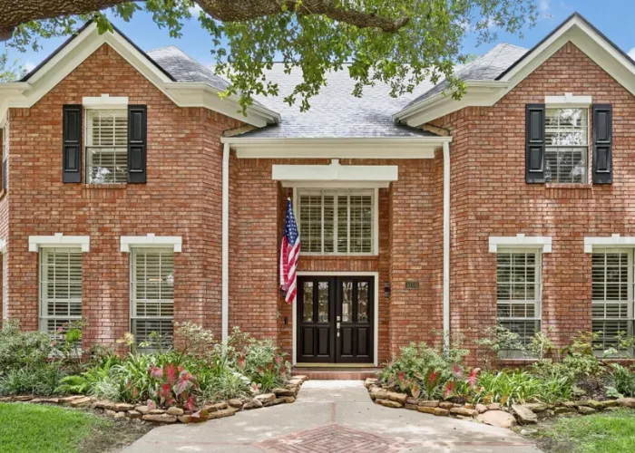 Classic two-story red brick home exterior with front entryway and garden at 4106 Trent Street, Sugar Land, TX 77479.