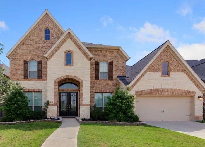 Beautiful two-story brick and stone home with a front lawn and garage at 4123 Abigail Way, Sugar Land, TX 77479.