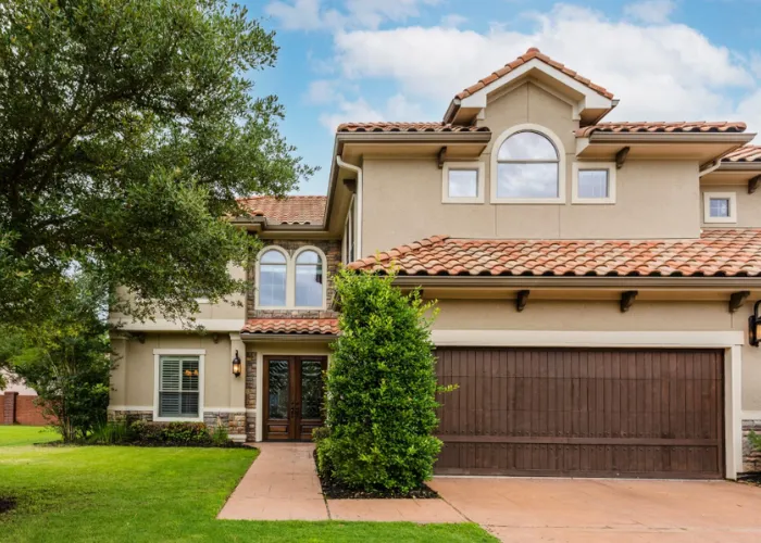 Elegant Mediterranean home with clay tile roof and front garage at 4302 Stonebrook Lane, Missouri City, TX 77459.