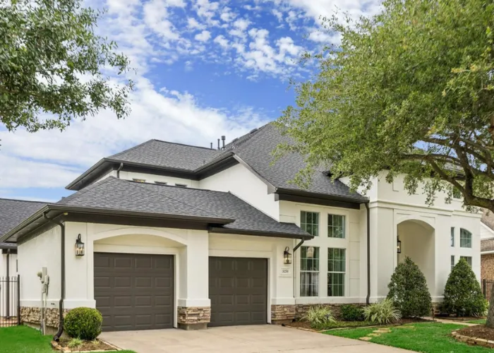 Elegant white luxury home exterior with a paved driveway located at 5230 Turning Leaf Lane, Sugar Land, TX 77479.