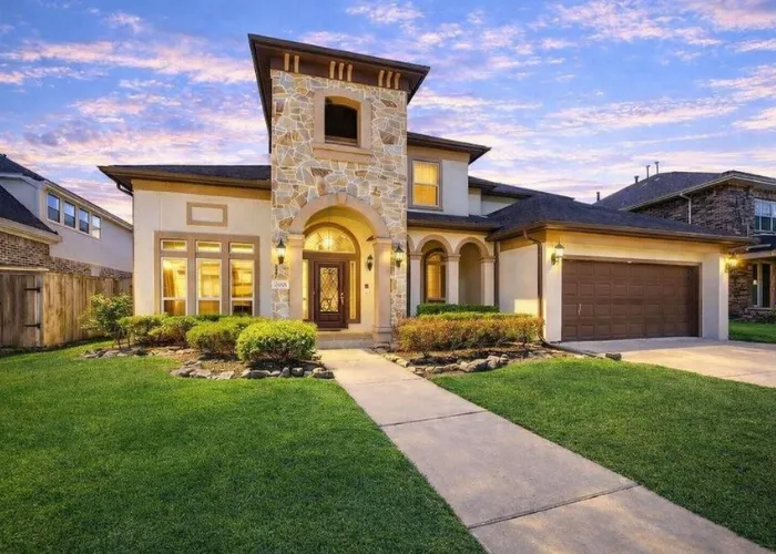 Beautiful Mediterranean style home exterior at 6015 Turner Shadow Lane, Sugar Land, TX 77479 with front lawn and walkway.